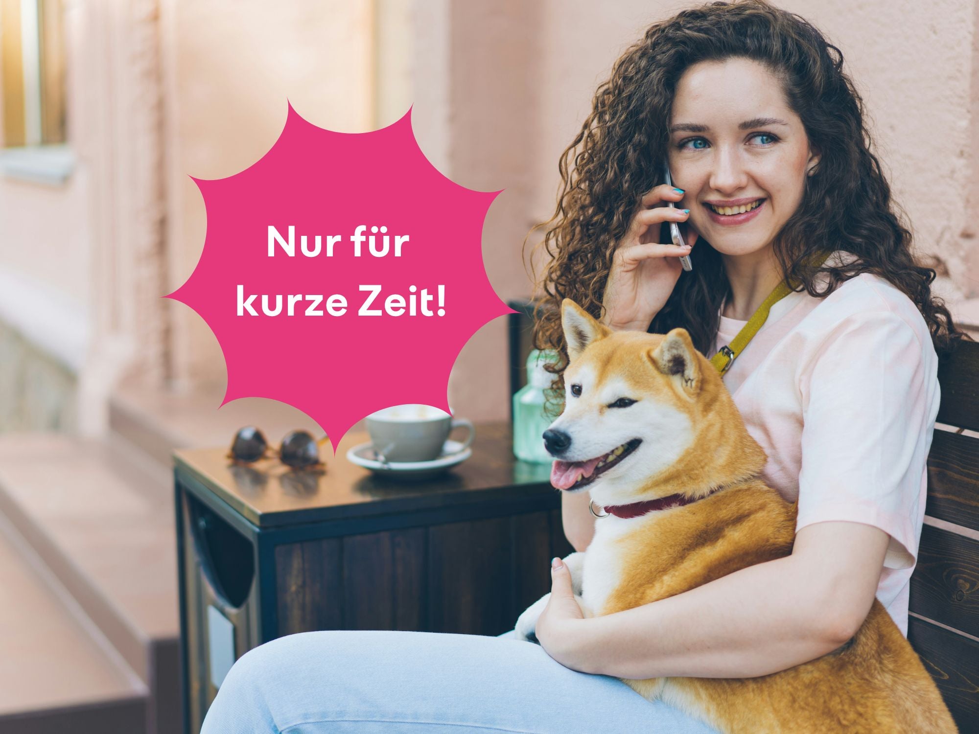 Frau sitzt auf einer Bank und telefoniert mit einem Hund im Arm