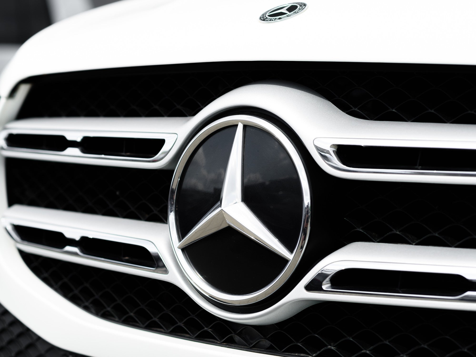 Front eines Mercedes mit Mercedes-Stern in der Nahaufnahme.