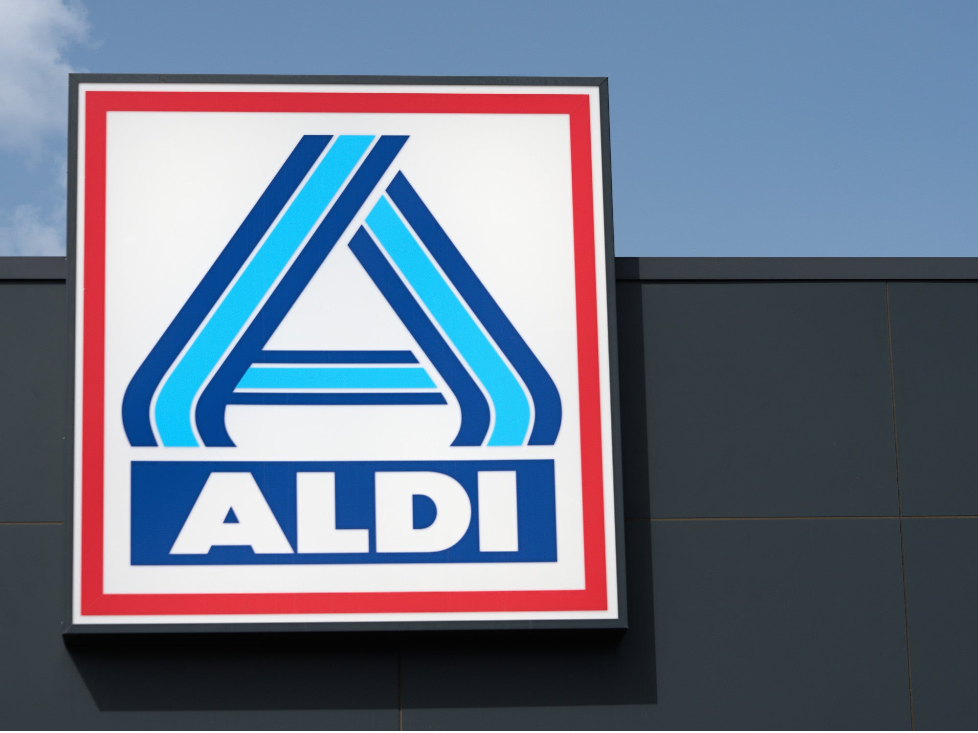 Aldi-Logo vor schwarz-blauem Hintergrund.