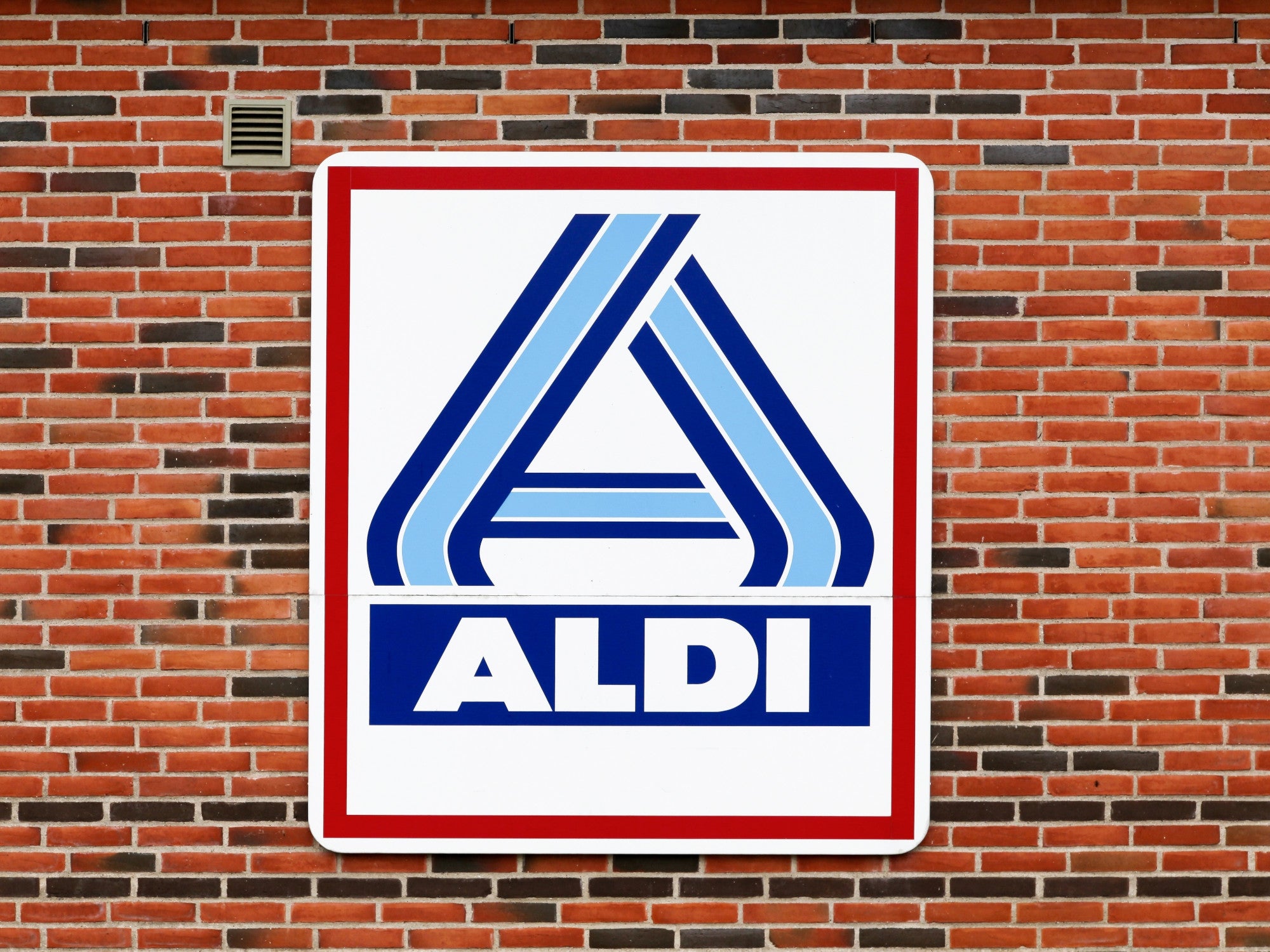 Aldi-Logo an einer Klinker-Hauswand.