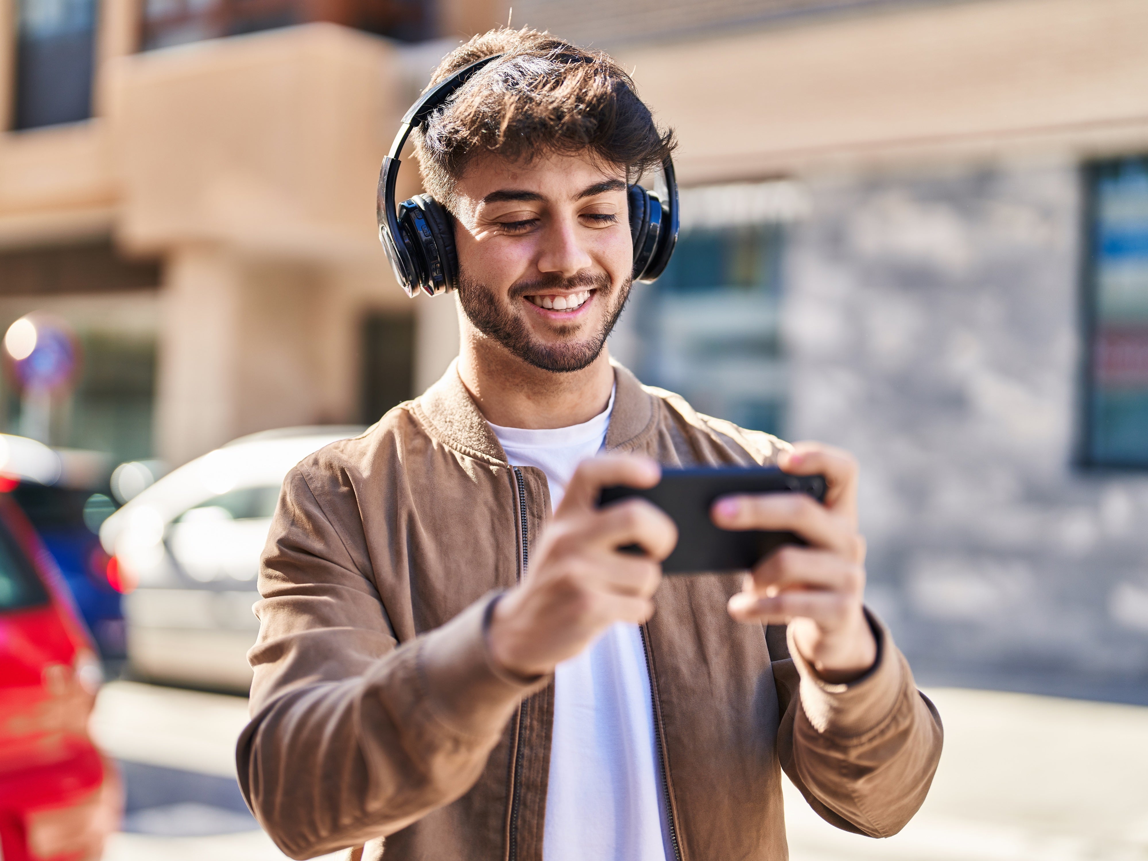 Mann mit Kopfhörern und Smartphone hört Musik