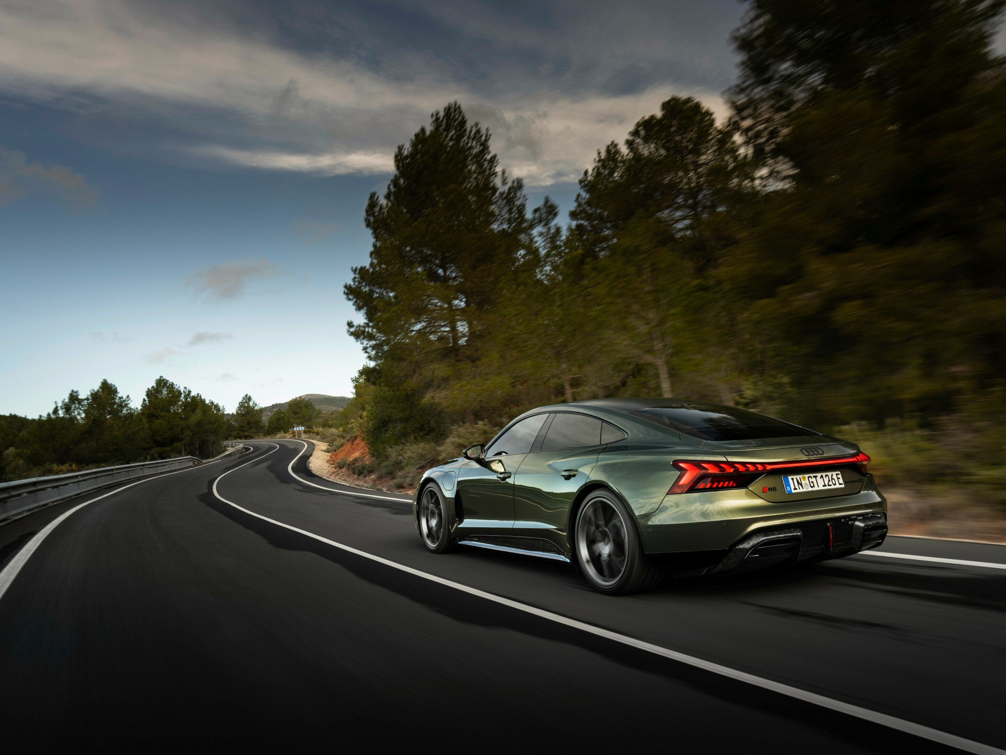 Audi e-tron GT performance während der Fahrt auf einer Straße in der Heckansicht.