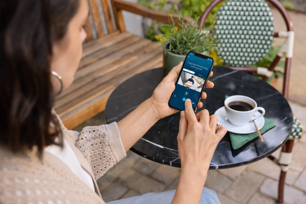 Bosch Smart Lock en un teléfono celular sostenido por una mujer.