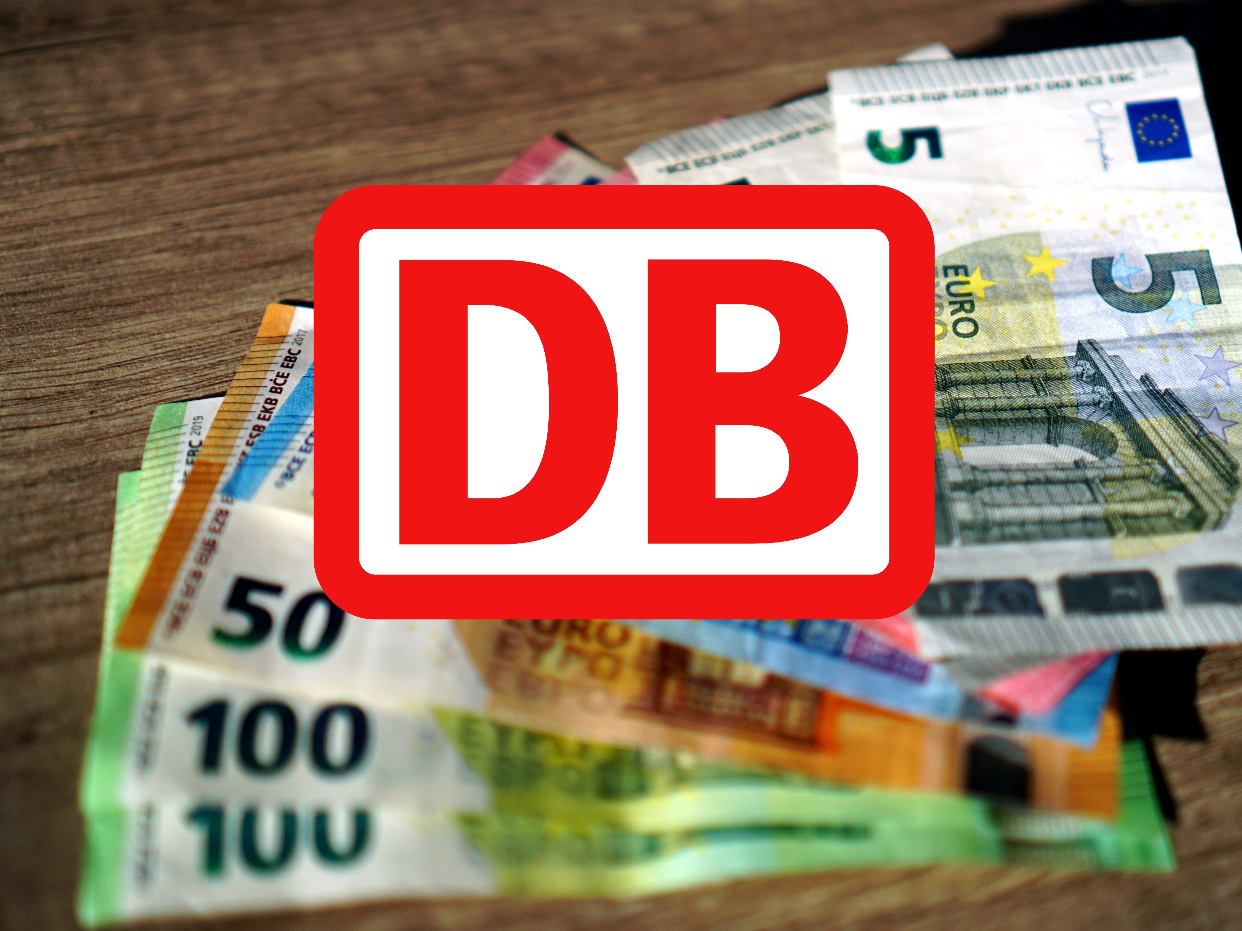 DB-Logo vor Geld im Hintergrund