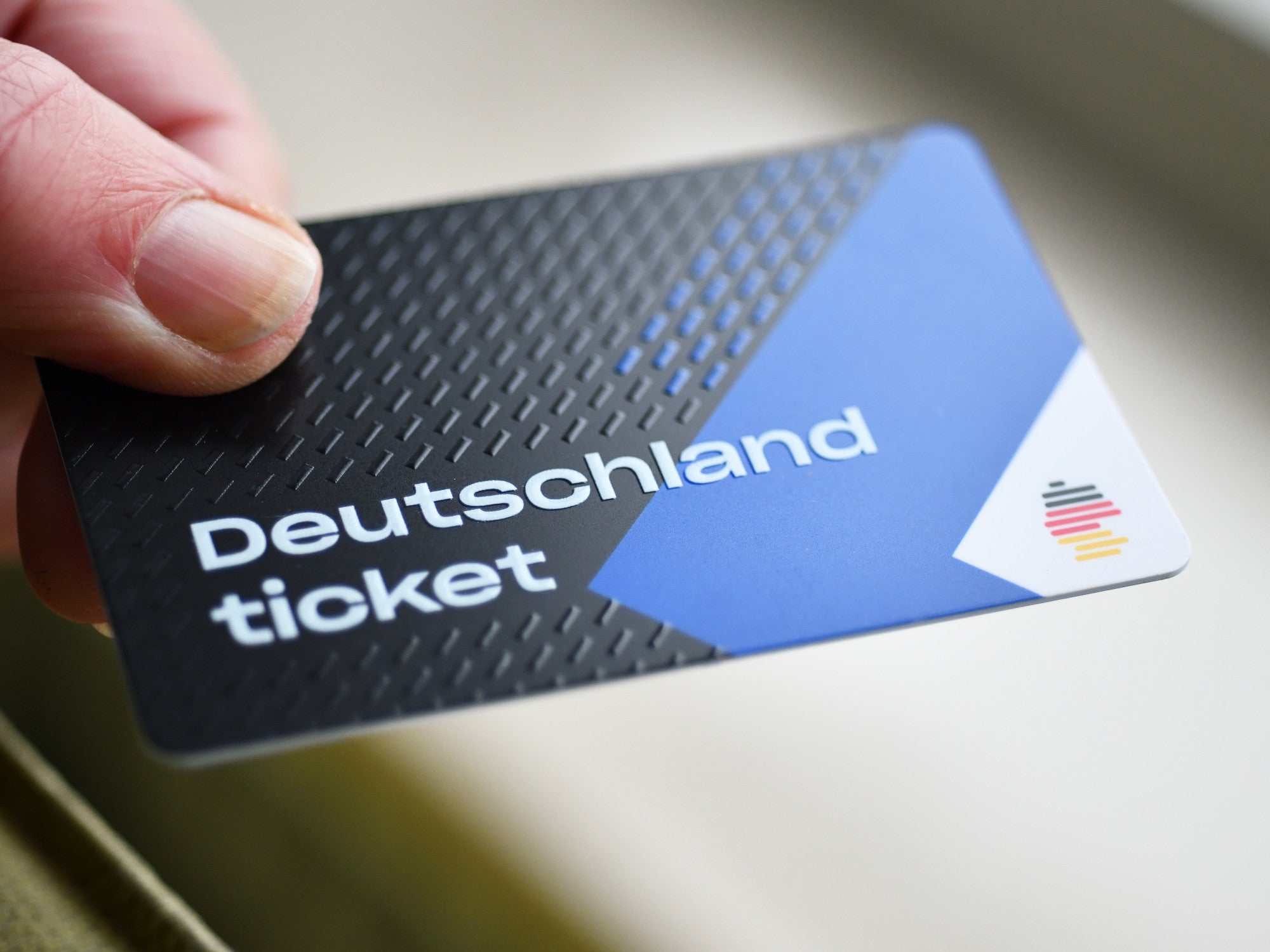 Deutschlandticket in der Hand eines Mannes.