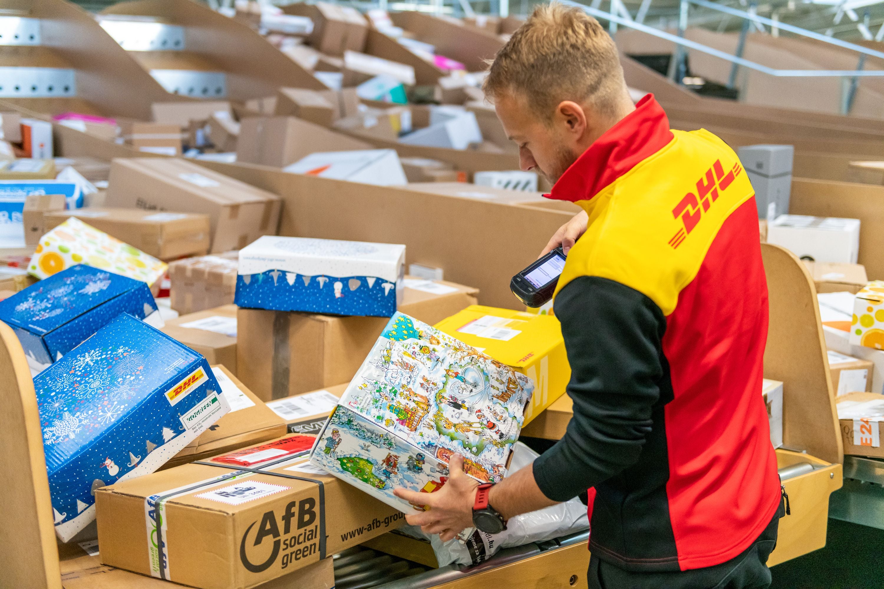 Ein DHL-Mitarbeiter scannt Pakete