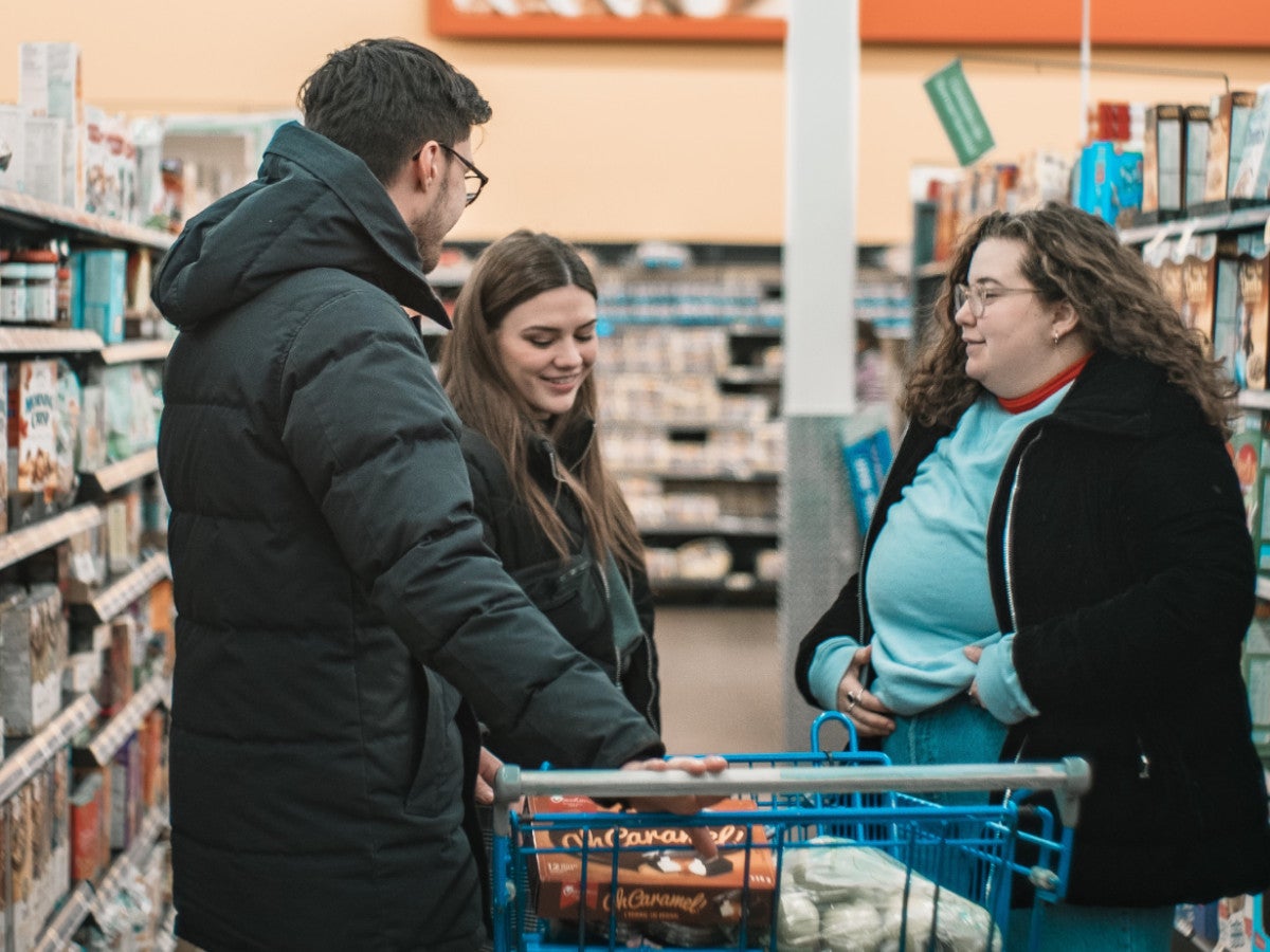 Entspannt einkaufen mit Einkaufs-Apps, so wie drei Menschen in einem Supermarkt