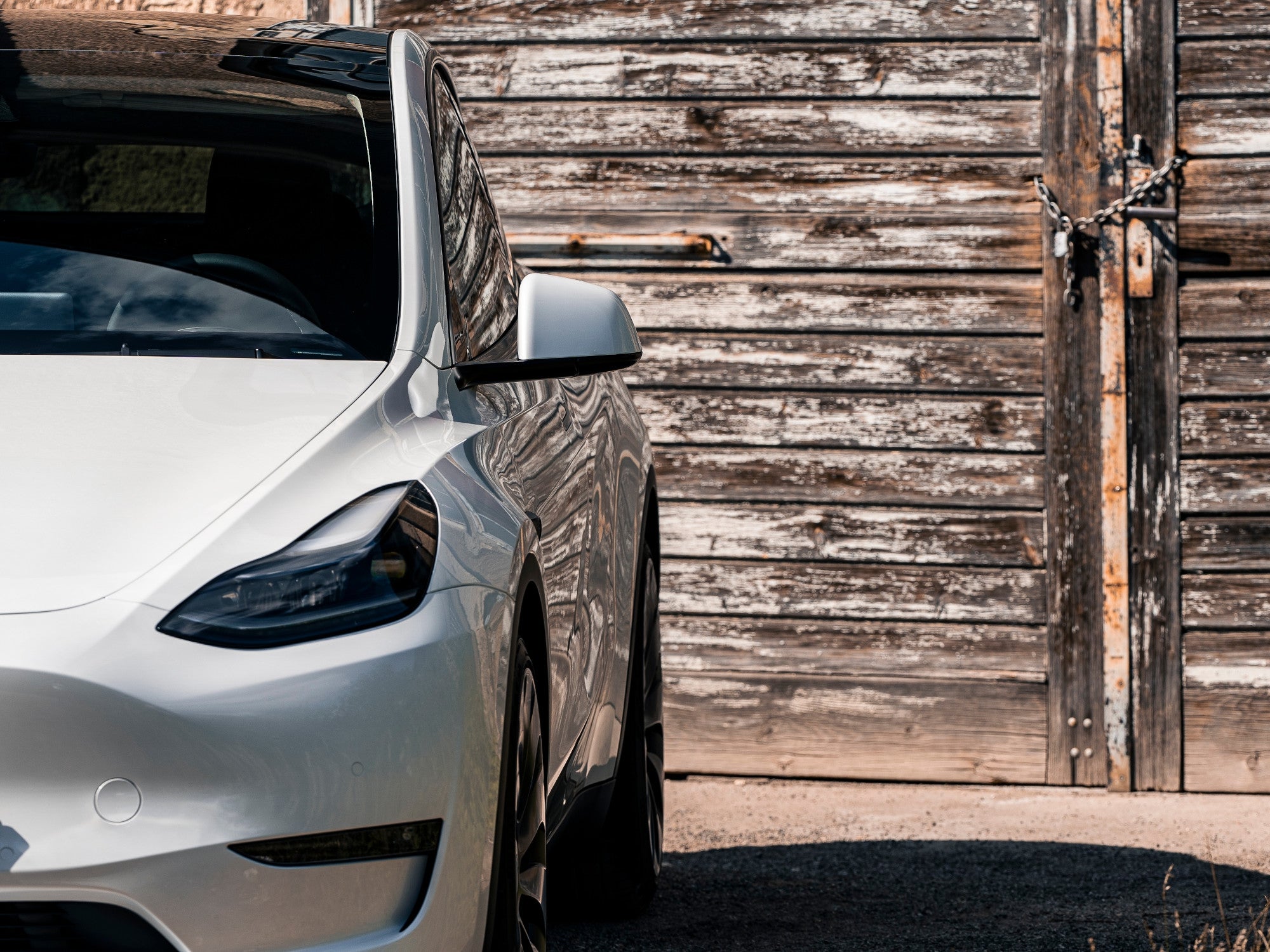 Front eines Tesla Model Y vor einem alten Haus.