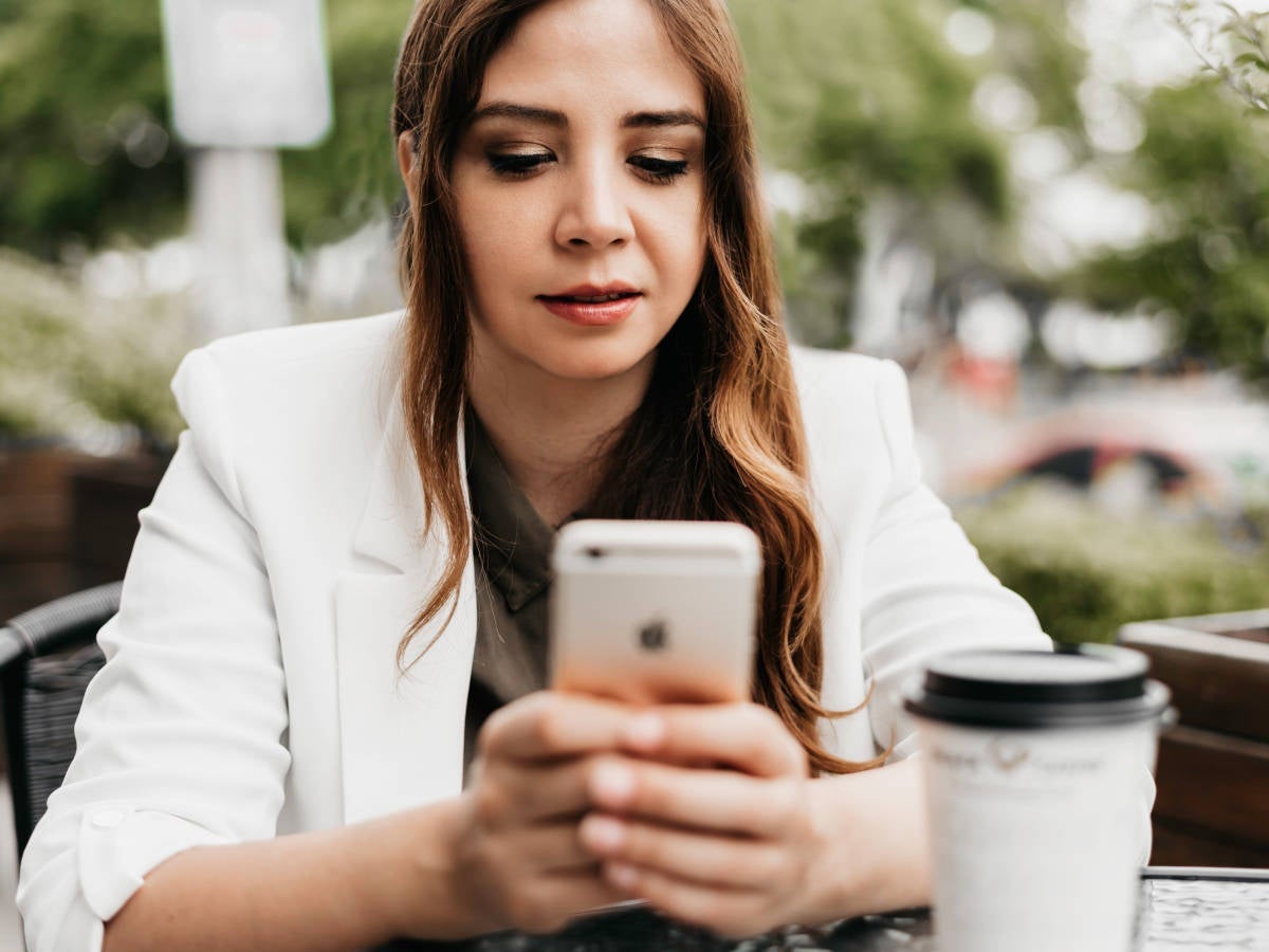 Frau mit Smartphone und Kaffee