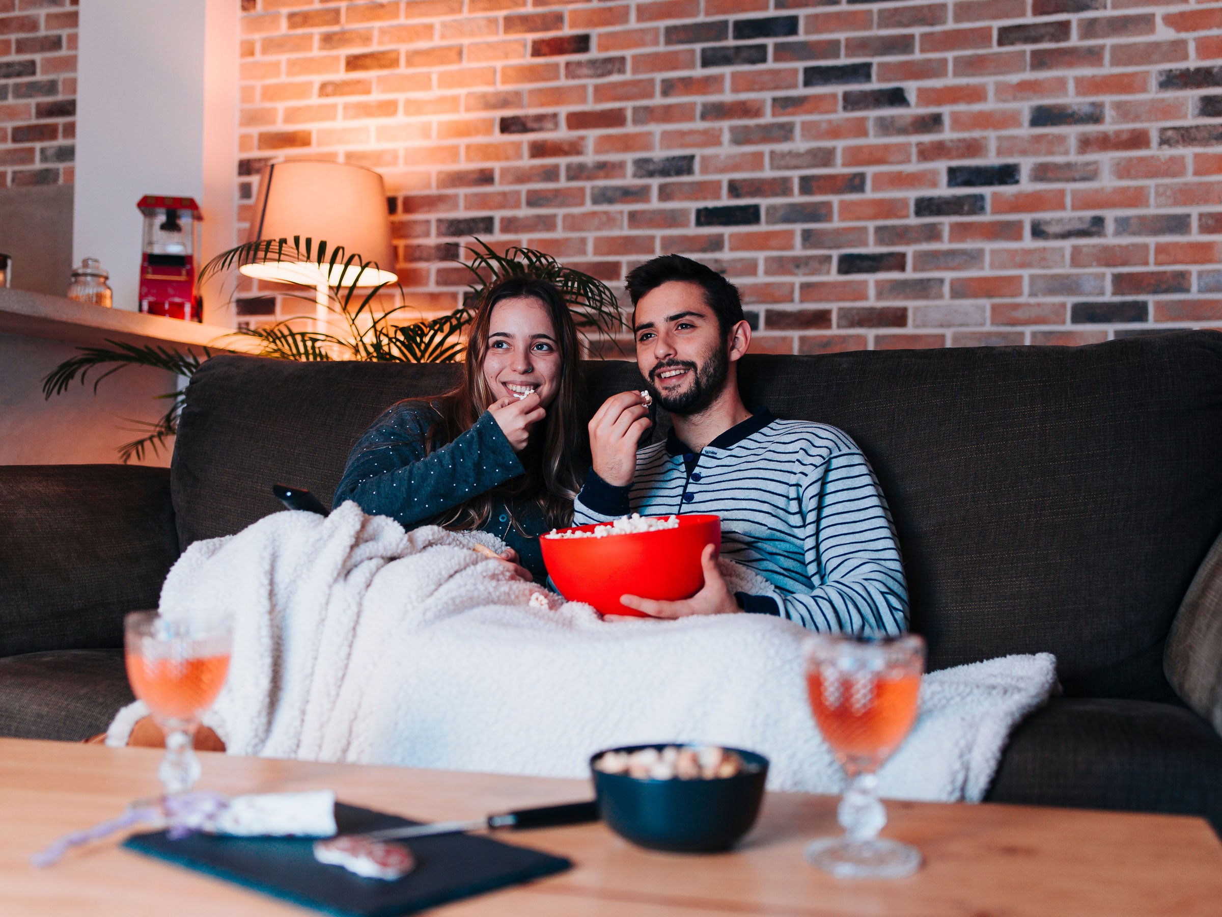 Ein Pärchen sitzt auf der Couch und schaut einen Film