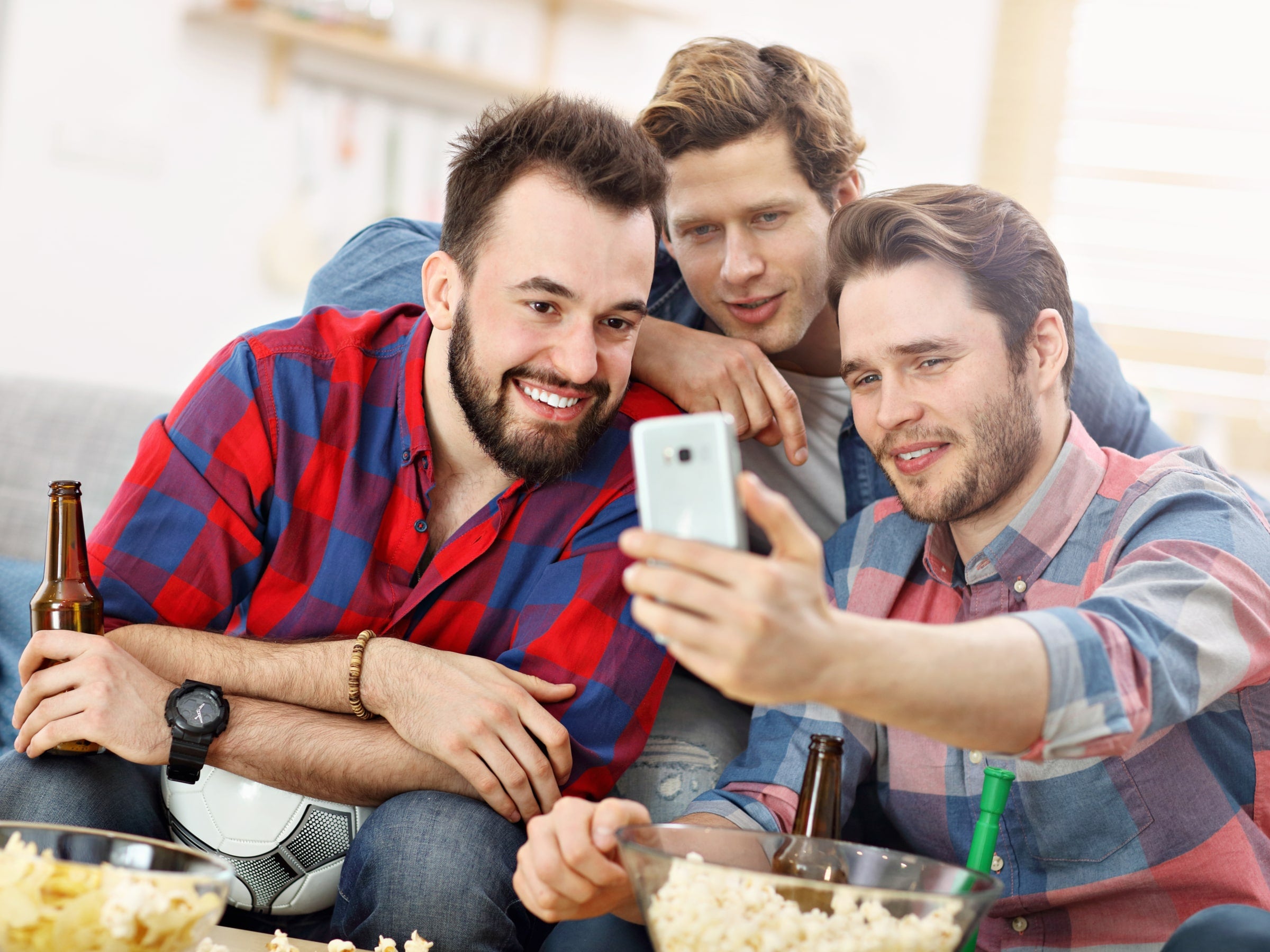 Männer schauen Fußball per App auf dem Handy