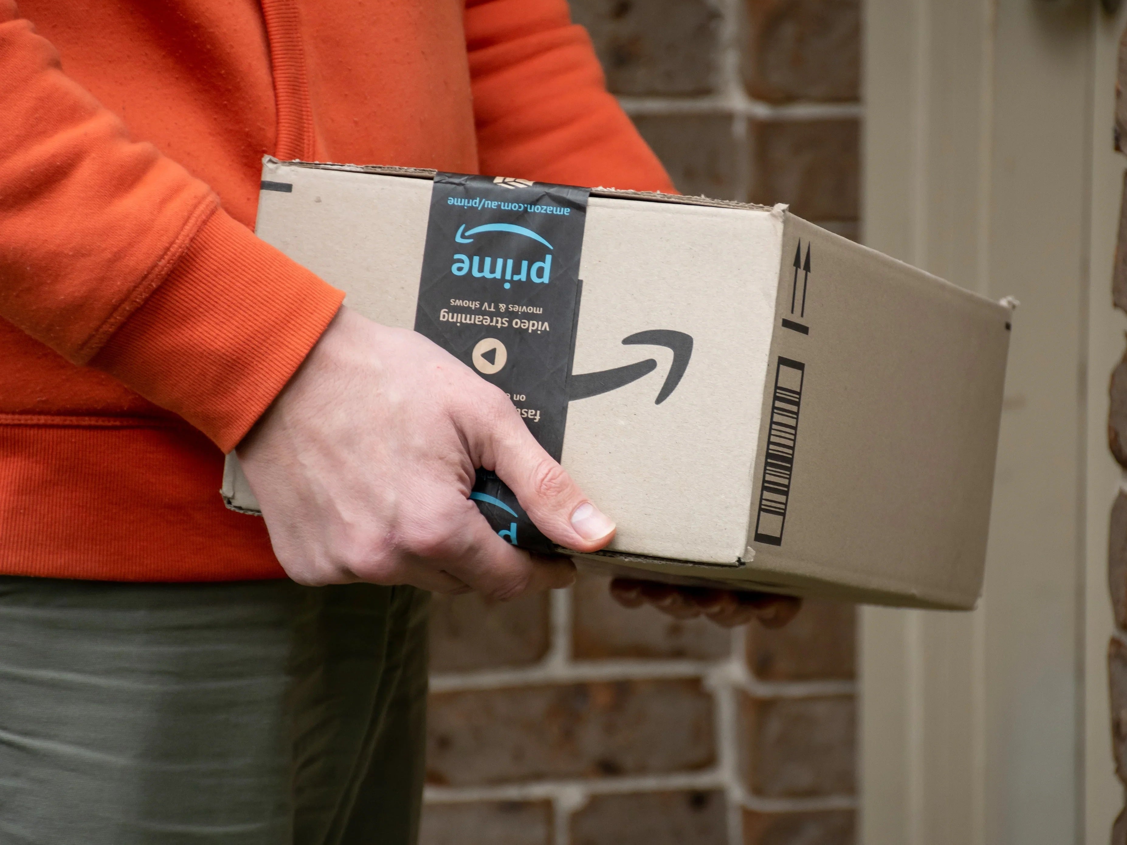 Mann hält Amazon-Paket in den Händen