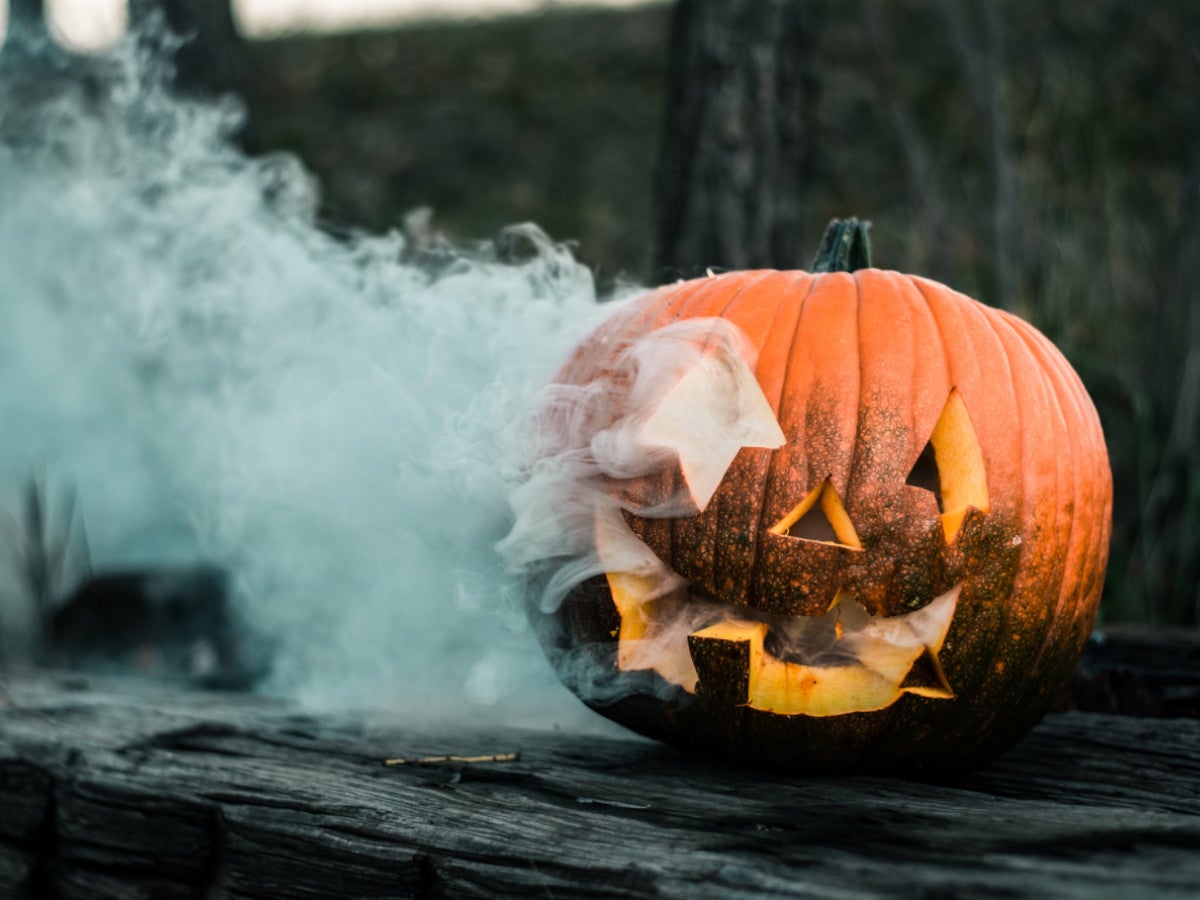 Halloweenkürbis mit Gesicht, aus dem Rauch aufsteigt.