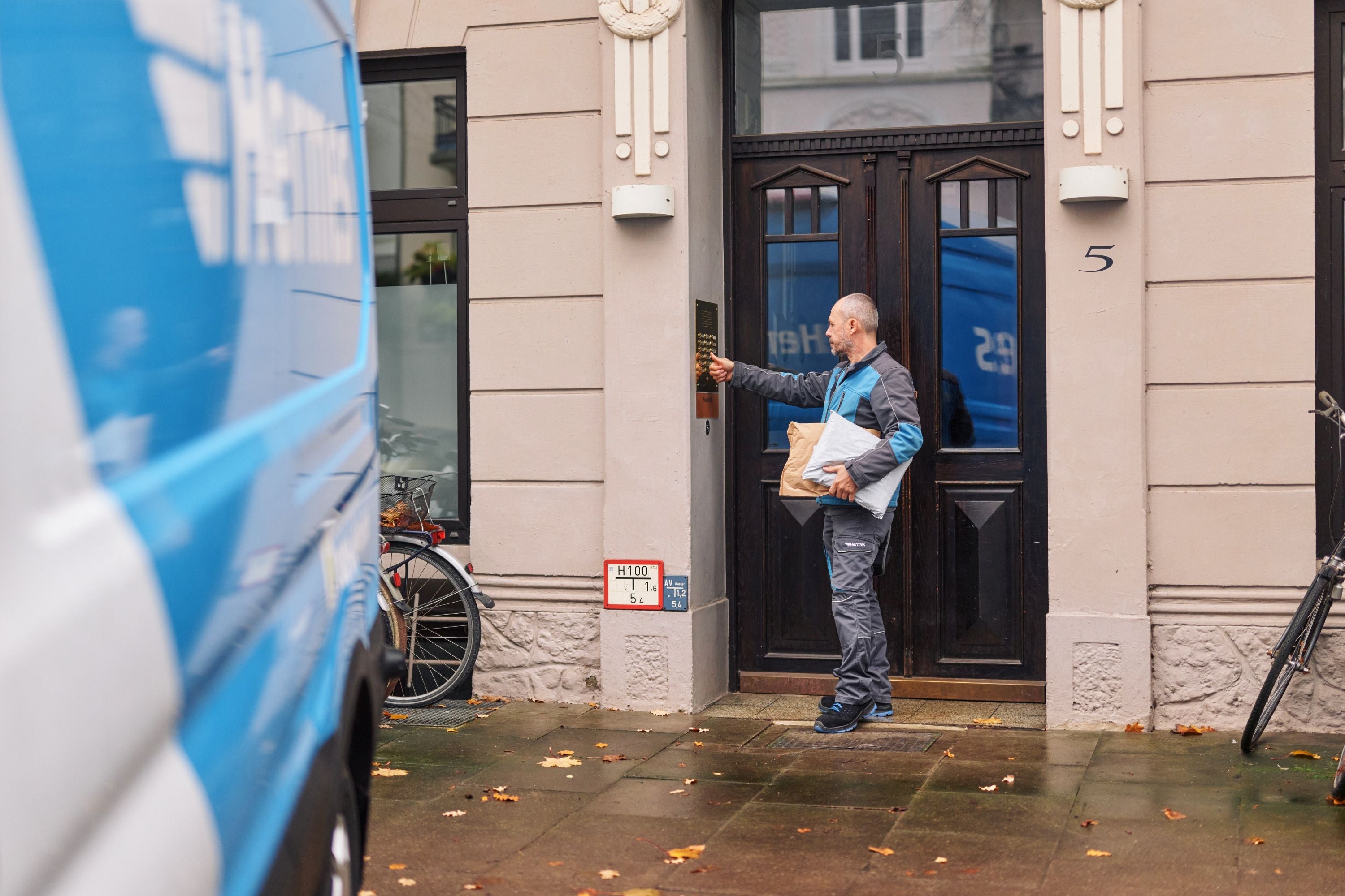 Ein Paketzusteller von Hermes vor einer Haustür