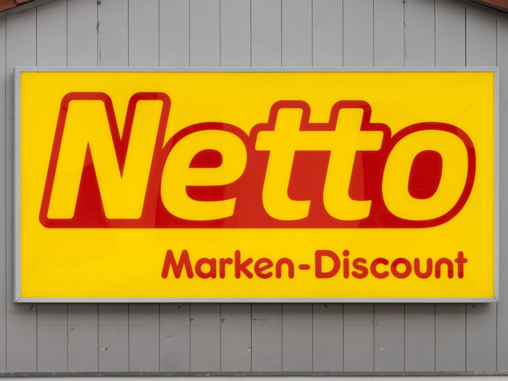 Logo von Netto an einer Fassade einer Filiale.