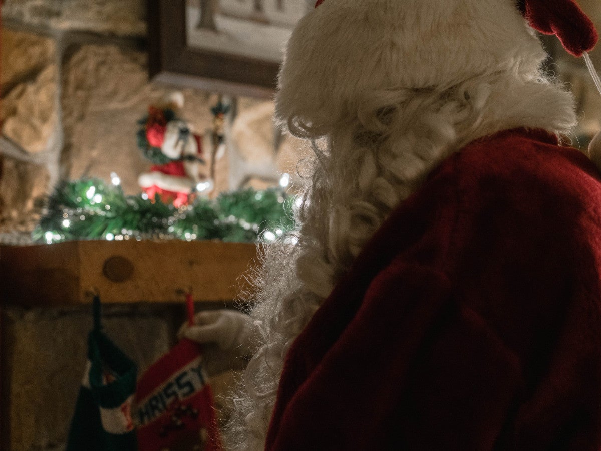 Ein Nikolaus steht mit dem Rücken zur Kamera und hat einen Nikolausstiefel in der Hand.