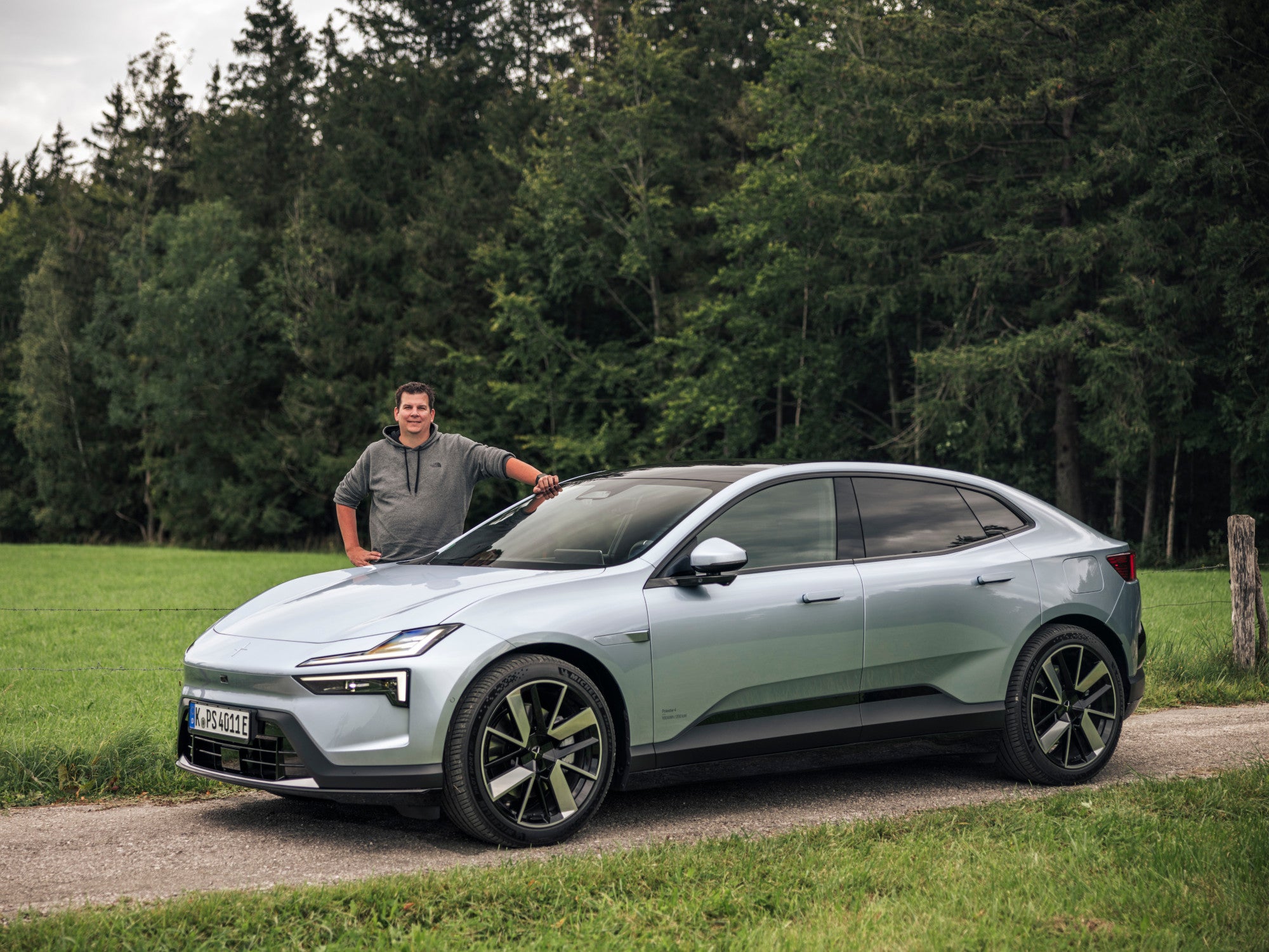 Polestar 4 und inside-digital-Redakteuer Hayo Lücke vor einem Wald in Bad Tölz.