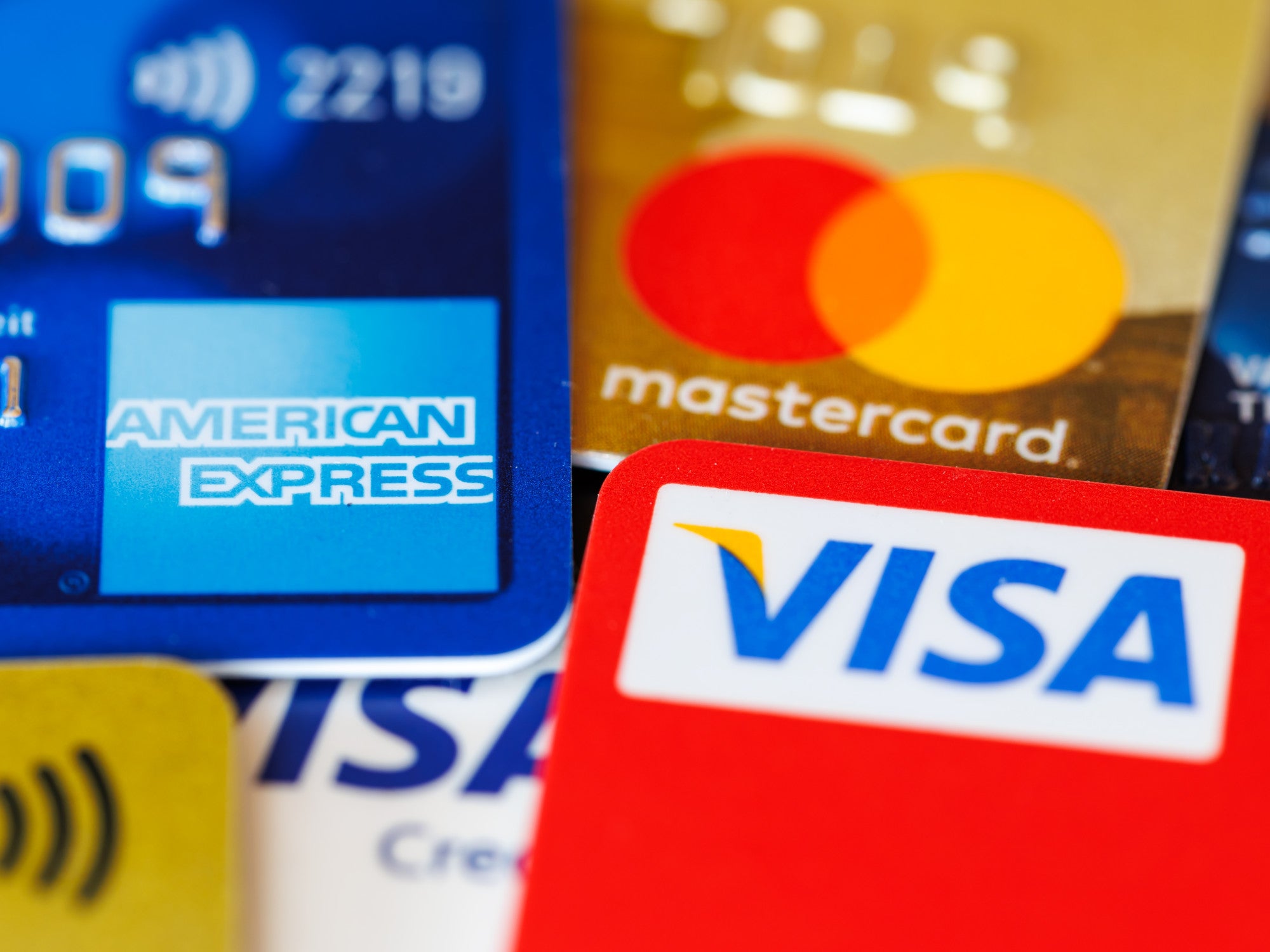 Kreditkarten von American Express, Mastercard und Visa liegen aufeinander.