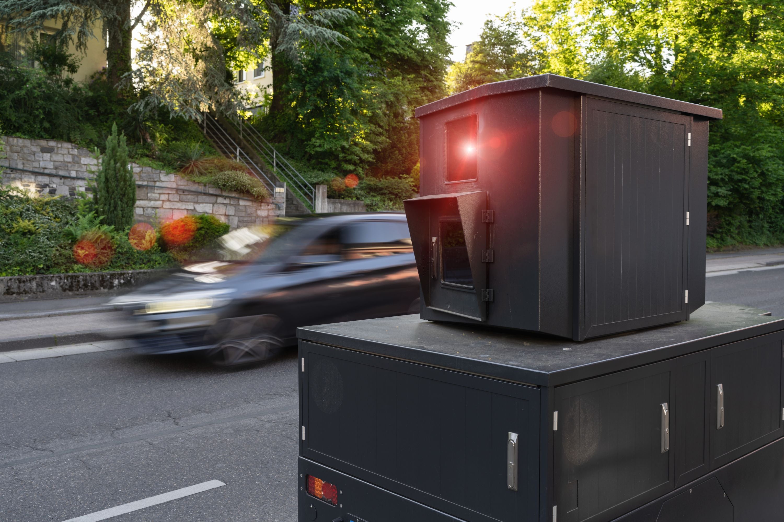 Eine Radarkamera am Straßenrand, im Hintergrund ein Auto