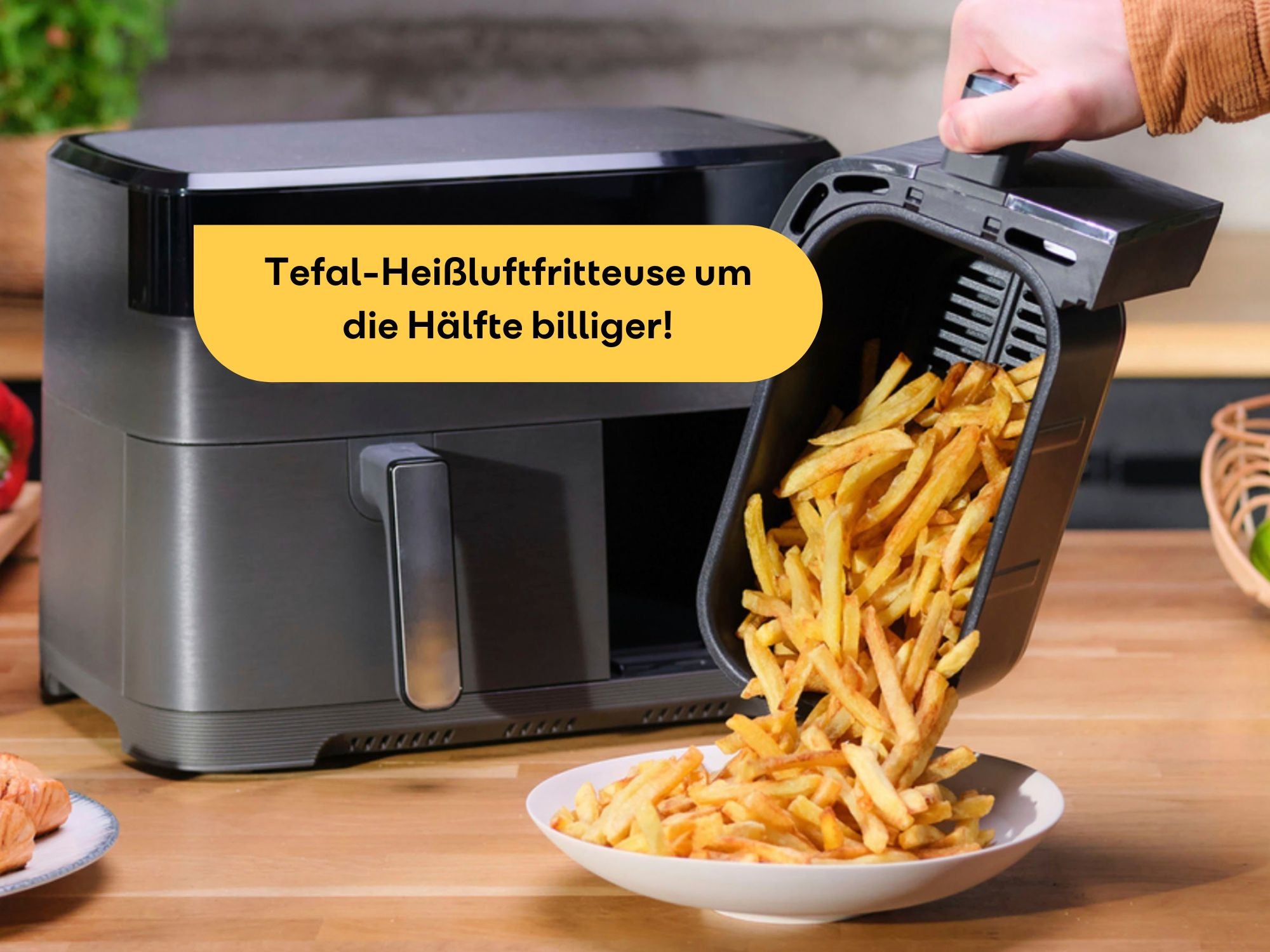 Heißluftfritteuse von Tefal steht mit einer Portion Pommes auf einem Tisch.