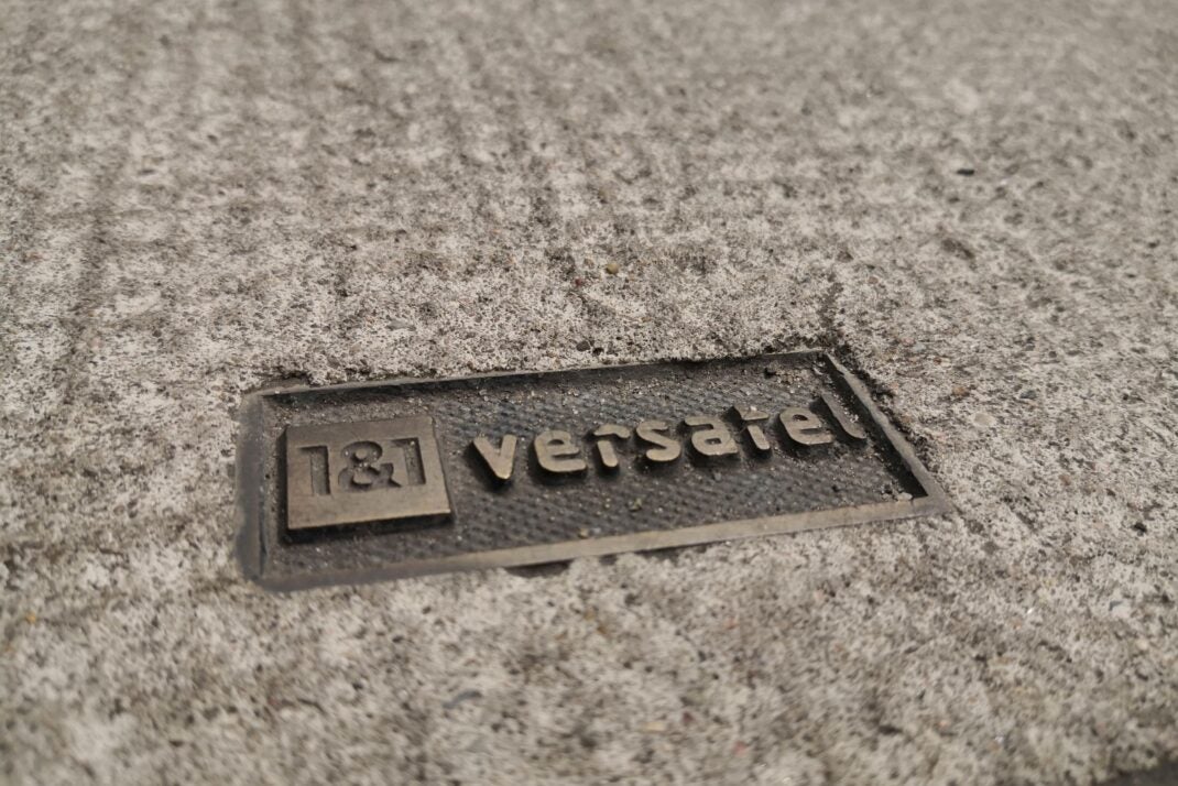 Ein Kanalschacht mit dem Logo von 1&1 Versatel