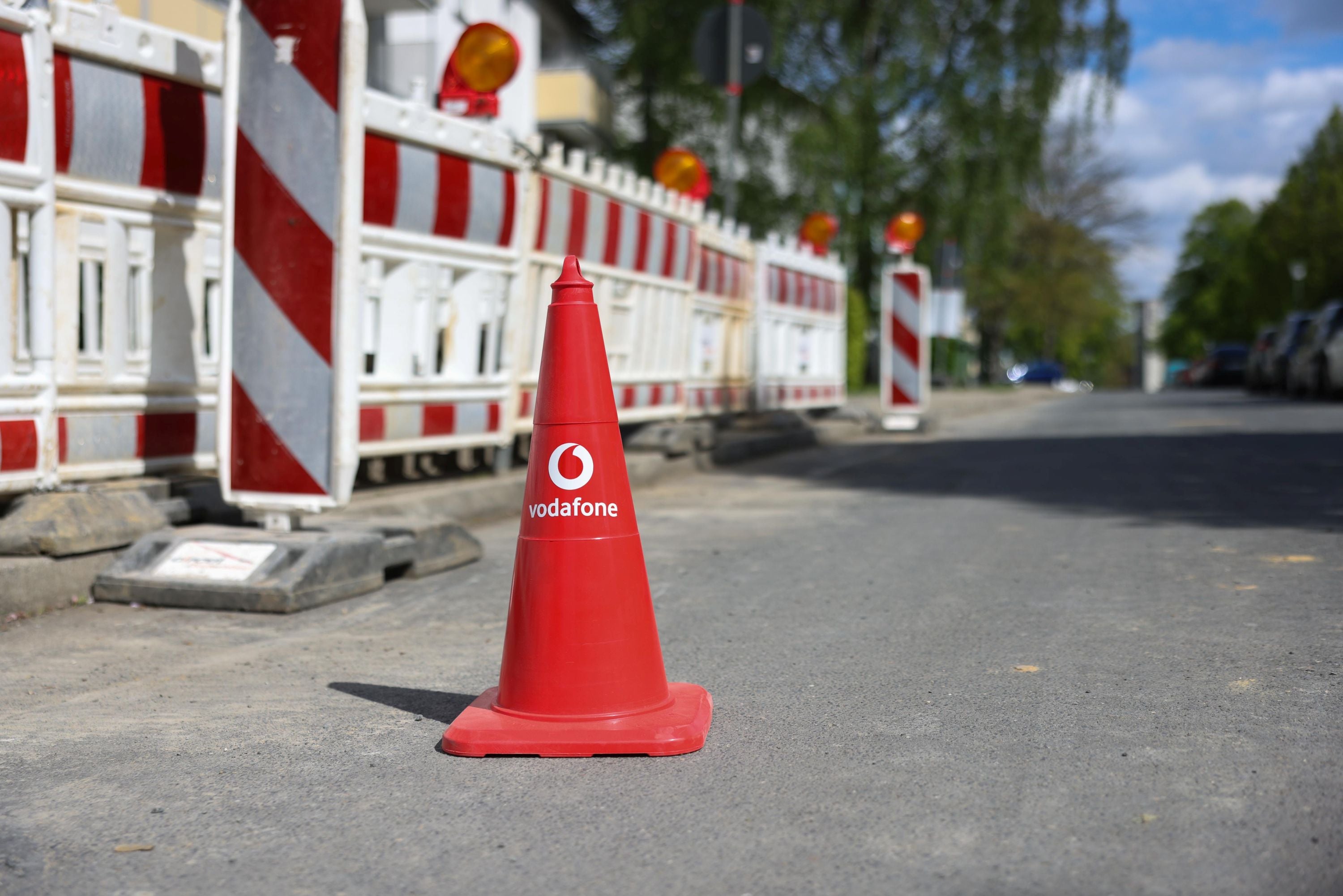 Ein Warn-Hütchen mit Vodafone-Logo vor einer Baustelle