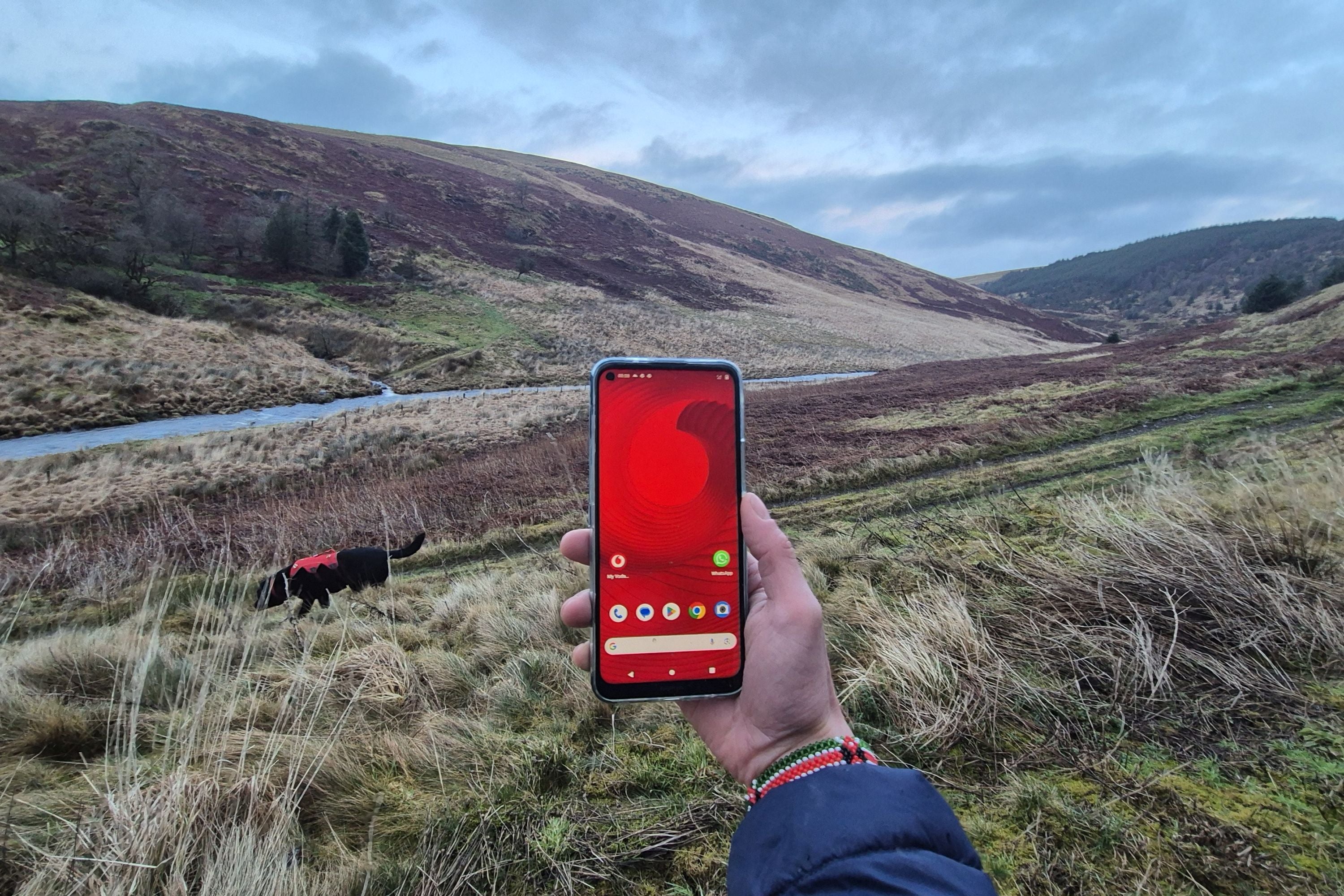 Ein Handy mit einem Vodafone-Logo vor der weiten Landschaft von Wales