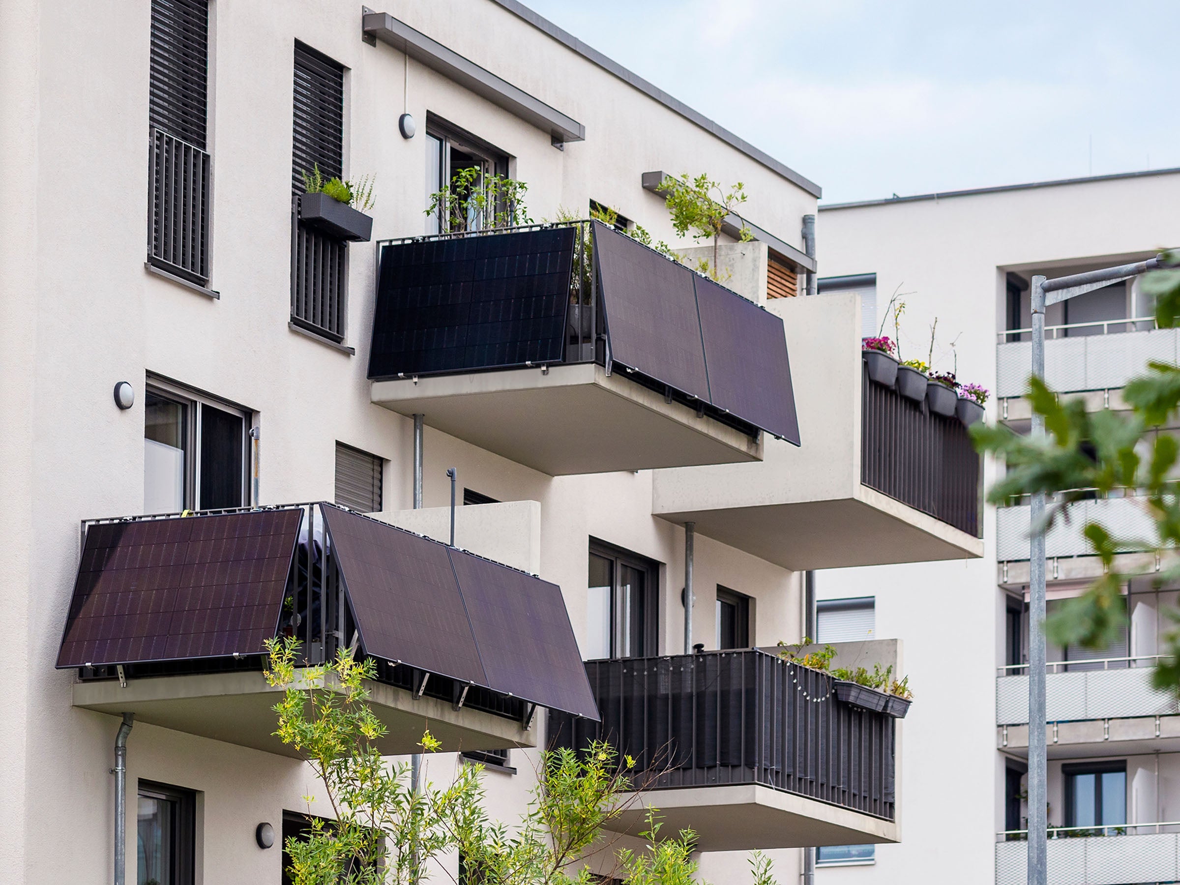 Balkonkraftwerke an Balkonen eines Mehrfamilienhauses.