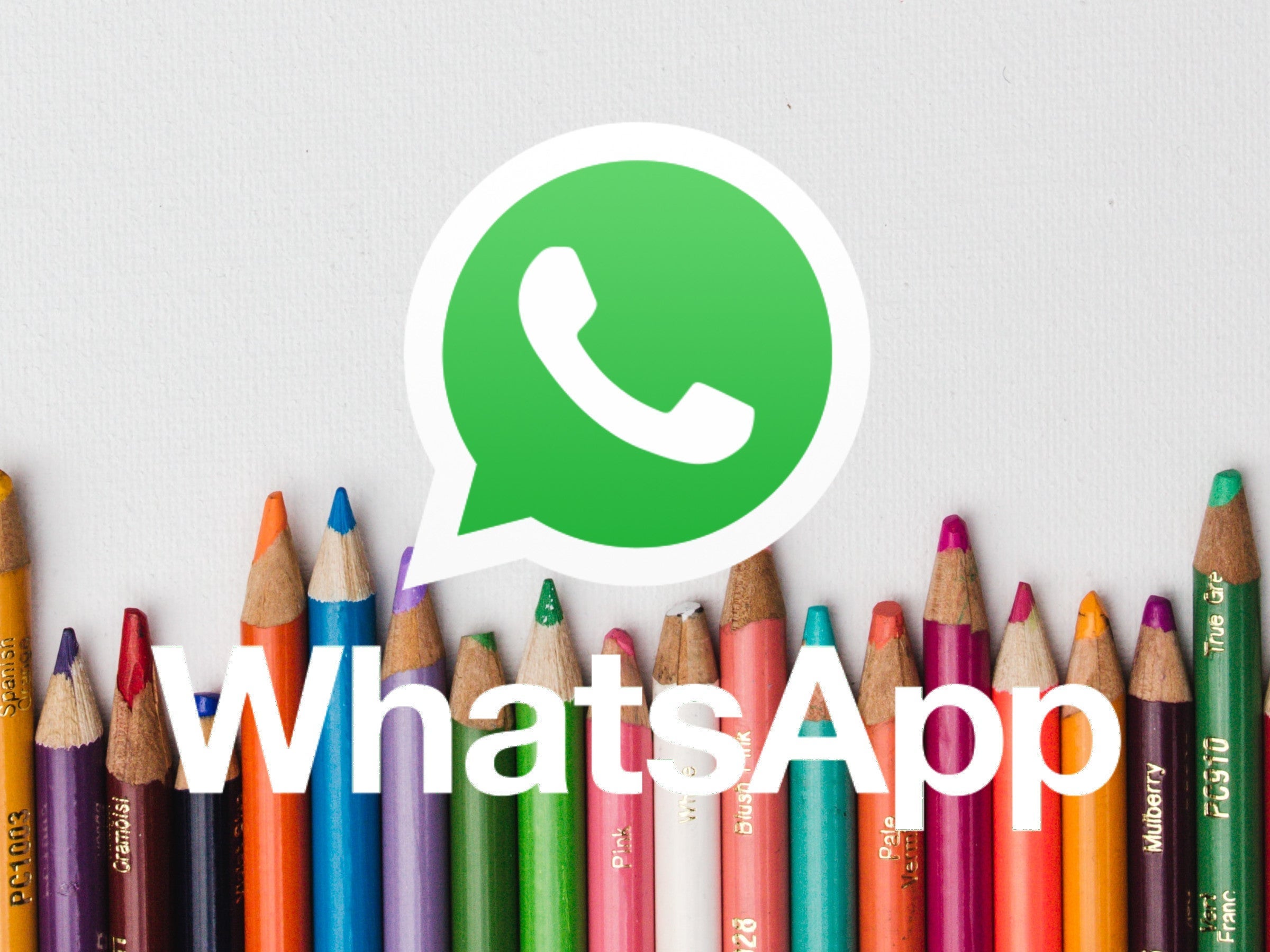 WhatsApp-Logo vor einer Reihe von Buntstiften