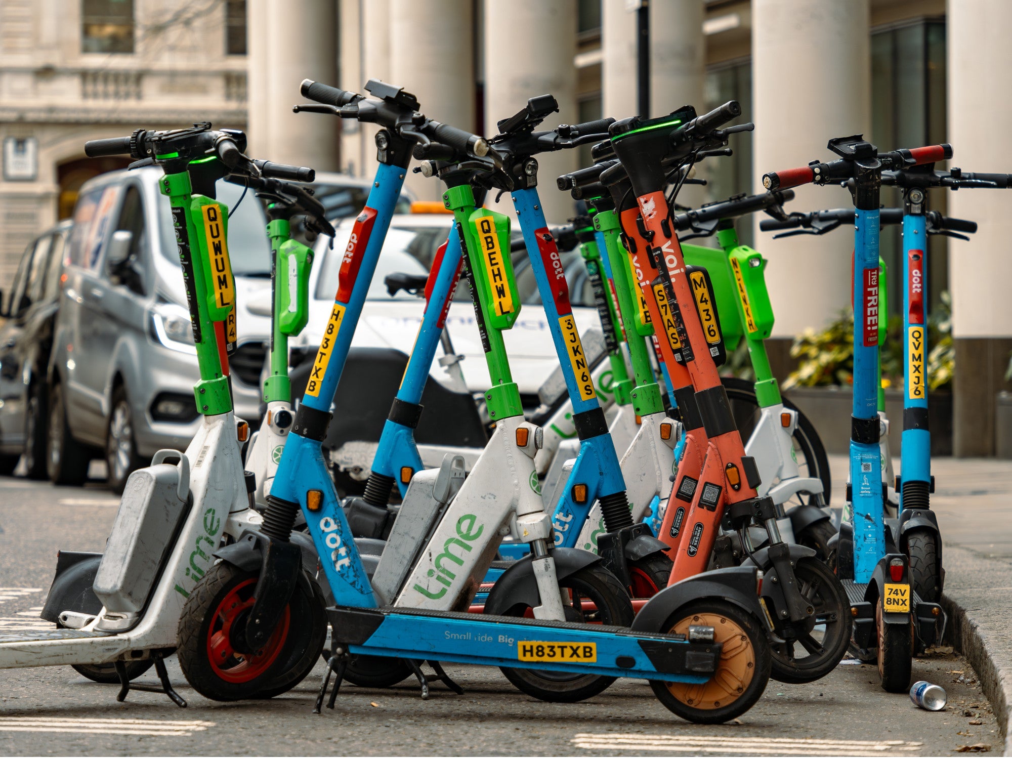 Leih-E-Scooter stehen wild geparkt am Straßenrand.